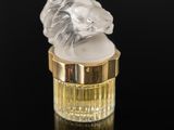an image of a glass perfume bottle with a lion head on top of it