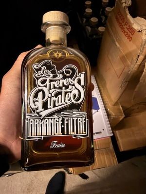 une bouteille d'alcool que quelqu'un tient à la main
