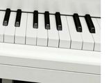a close up of a white piano with black and white keys