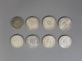 six types de pièces différents alignés sur une surface grise