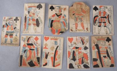 Plusieurs vieilles cartes à jouer sont disposées en rangée sur une table