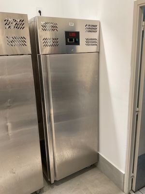 two stainless steel refrigerators next to each other in a room