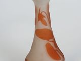 an orange and white vase sitting on a white surface