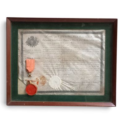 un vieux document orné d'un ruban rouge et d'une médaille, dans un cadre en bois