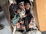 une boîte remplie de poupées posées par terre