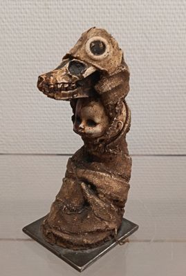a statue of a bird with a human head on it ' s head