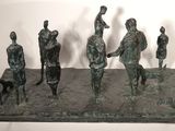 statue représentant un groupe de personnes avec un chien et un oiseau posés sur une table