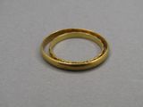 gros plan d'une bague en or sur une surface grise