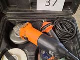 une ponceuse électrique orange et noire rangée dans un coffret noir