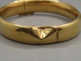 une image d'un gros plan d'un bracelet en or sur une table