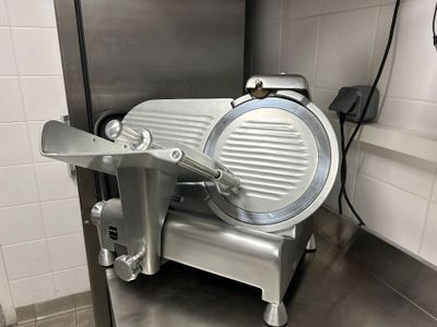 a meat slicer that is sitting on the counter