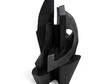 une sculpture abstraite représentant un morceau de métal noir posé sur une surface blanche