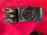 a black camera with a lens attached to it on a red surface