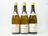 trois bouteilles de vin posées les unes à côté des autres sur une surface blanche