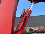 an image of a red excavator in a parking lot