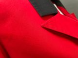 close up of a man in a red suit with a black tie