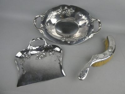 a silver plate with a spoon and a brush