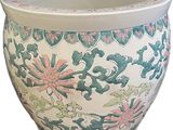 un vase blanc orné d'un motif vert et rose
