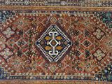 an antique persian rug with a geometric design on a blue ground