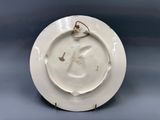 a white plate with a bird on it on a blue background