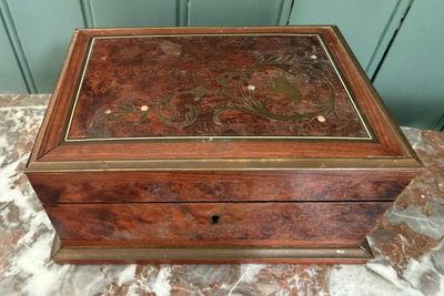 une vieille boîte en bois dont l'intérieur est orné d'un motif floral