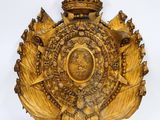une plaque ancienne en bois surmontée d'une couronne