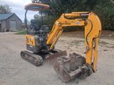 a small yellow excavator that is parked in the dirt