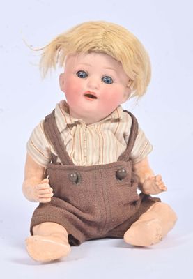 doll with blonde hair and overalls sitting on white surface