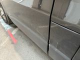 a car that has been dented and is parked on the side of the street