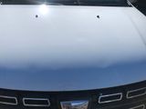 the hood of a blue pickup truck parked in a parking lot