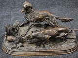 bronze statue of a dog and a cat on a rock
