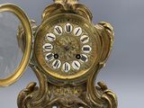 une horloge dorée avec des chiffres romains et un miroir