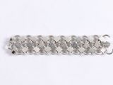 a close up of a silver bracelet on a white surface