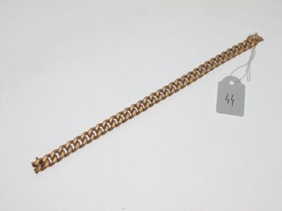 Gros plan sur un bracelet en chaîne en or portant une étiquette