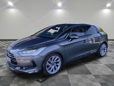 a grey car is parked on a checkered floor in a garage