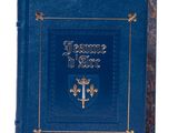 un vieux livre bleu aux bords dorés, avec une croix sur la couverture