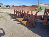 une photo montrant une rangée d'outils de labour dans un champ