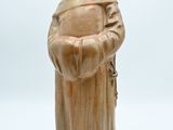 statue d'un moine en robe, tenant un chapelet, sur fond blanc