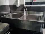 a stainless steel sink in a kitchen with a large mirror