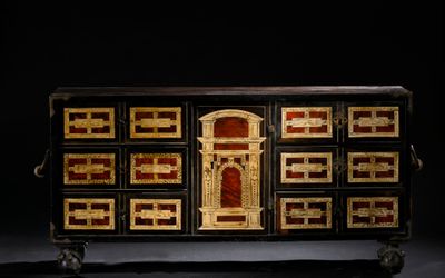 a black and gold chest of drawers with a clock on top