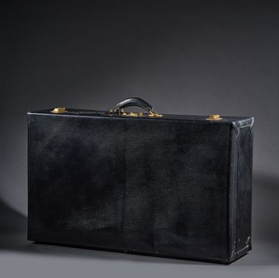 a black suitcase sitting on top of a table next to a wall