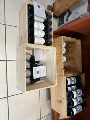 plusieurs bouteilles de vin dans une caisse en bois accrochée au mur