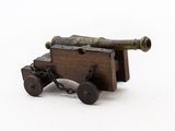 a small wooden cannon on wheels on a white surface