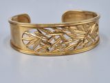 une image représentant un bracelet manchette en or orné de feuilles