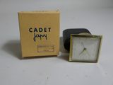 a small clock that is sitting in front of a box