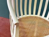a white chair with a wicker seat on a red floor