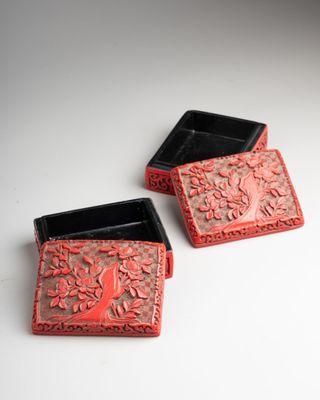 deux boîtes rouges et noires posées sur une table blanche