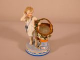 a figurine of a boy holding a basket of flowers