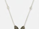 un gros plan d'un collier orné d'un papillon