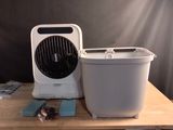 un petit ventilateur posé sur une table, à côté d'une poubelle